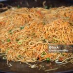Closeup of Chowmein on Black Pan with Selective Focus in a Street Food Stall in Horizontal Orientation.